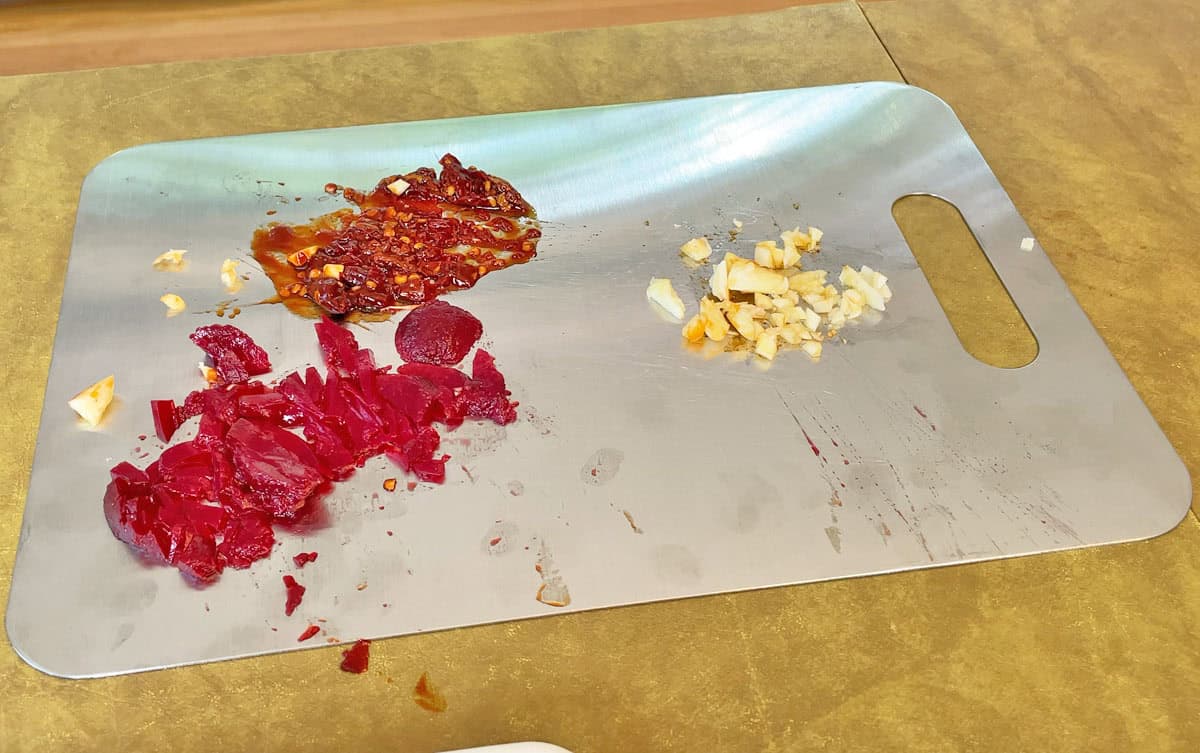 Beets chipotle peppers and garlic on a titanium cutting board