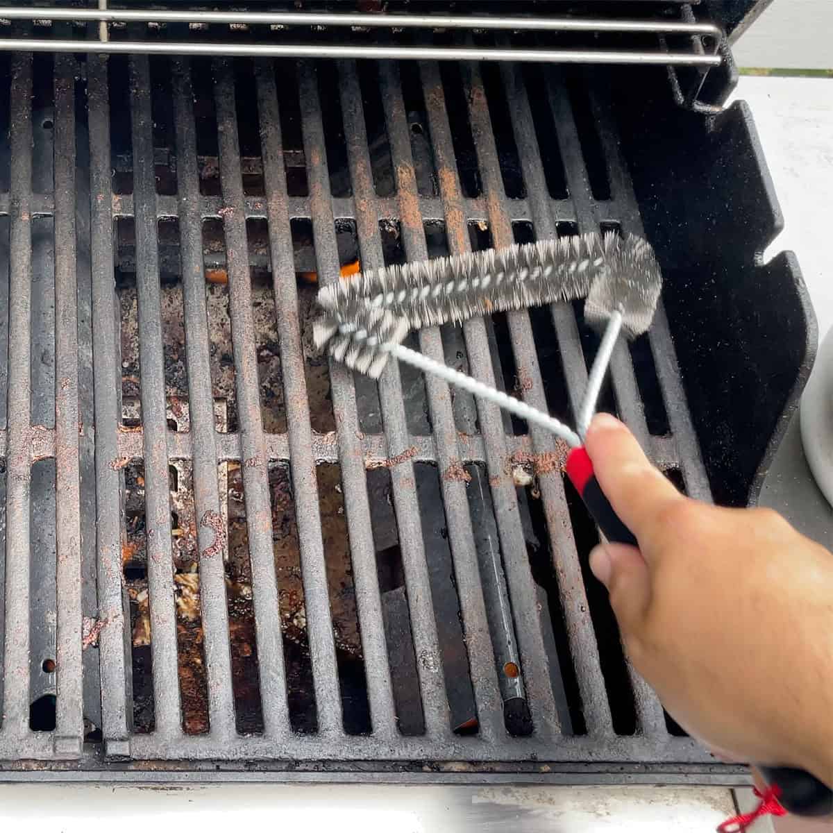 Cleaning a grill with the Weber 12 inch three-sided grill brush