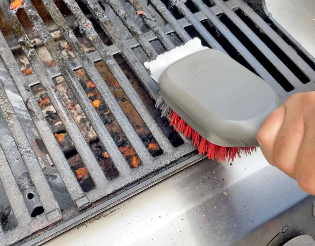 Cleaning dirty grill grates with OXO grill brush