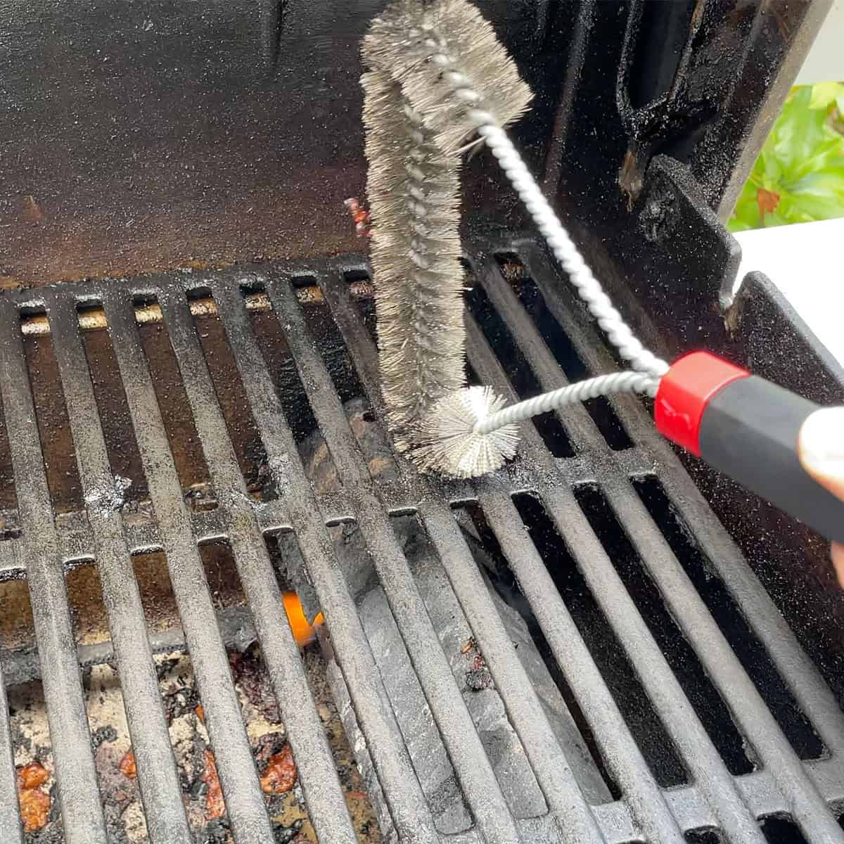 Cleaning dirty grill grates with Weber grill brush