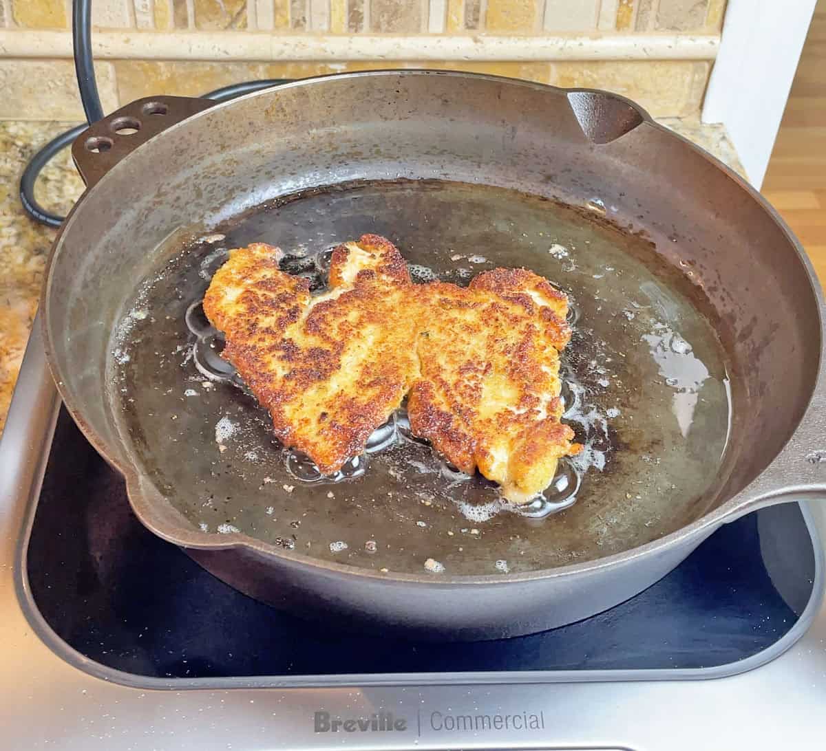 Cooking a chicken cutlet on a Smithey pan on an induction cooktop