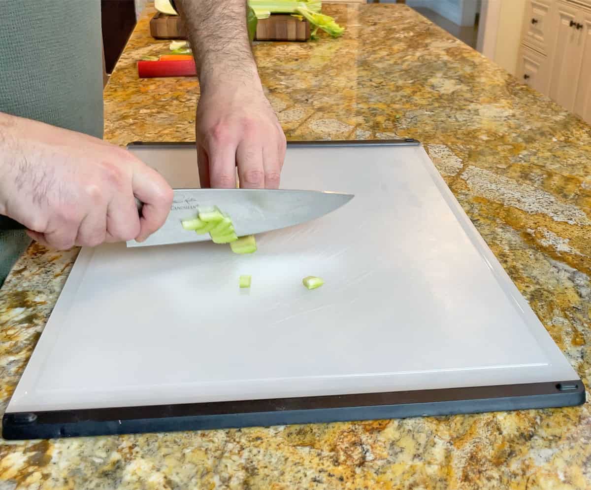 Cutting celery on a plastic cutting board