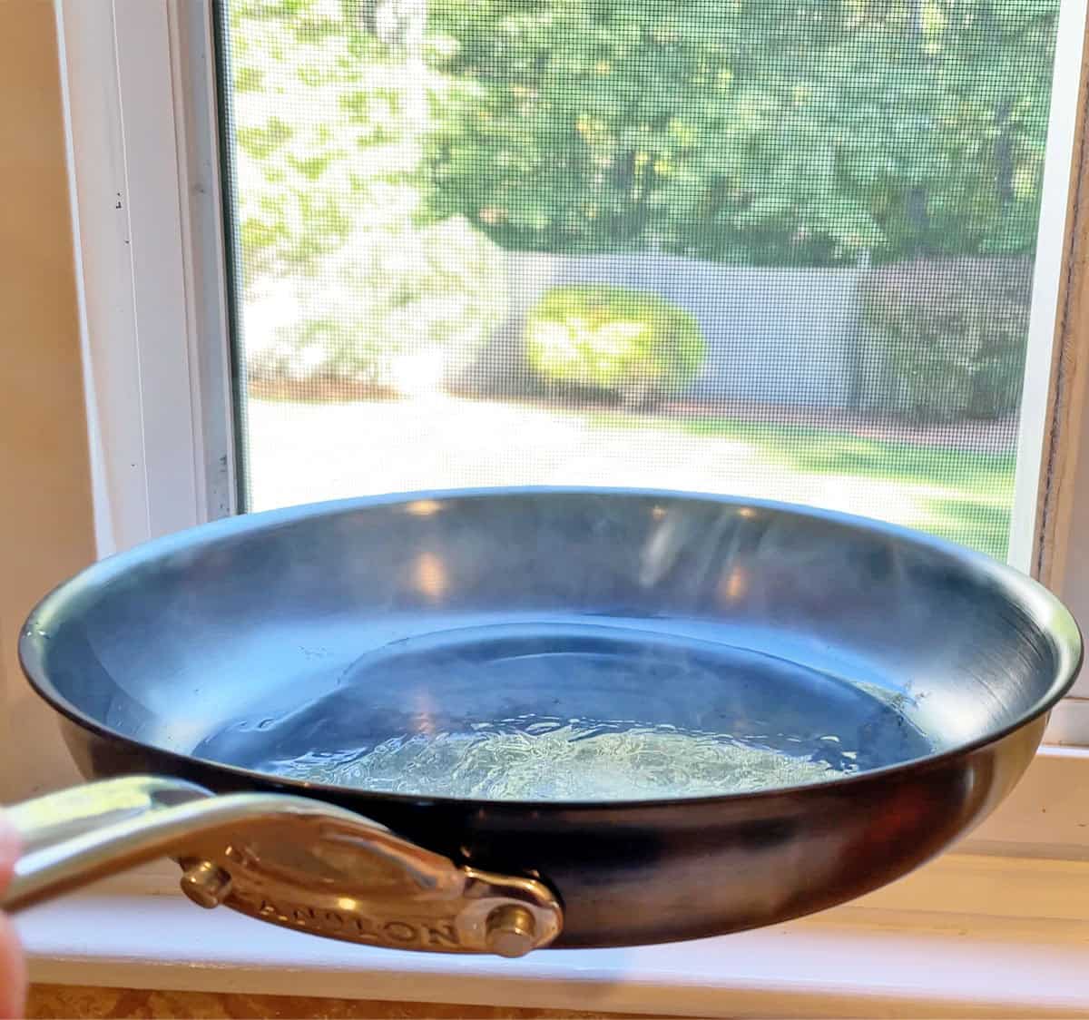 Holding Anolon EverLast N2 near the window becuase it was overheating and oil was smoking