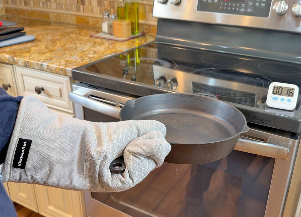 Oven mitt heat test holding a hot cast iron skillet