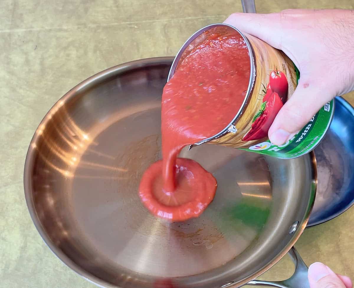 Pouring tomato sauce into a seasoned Strata pan