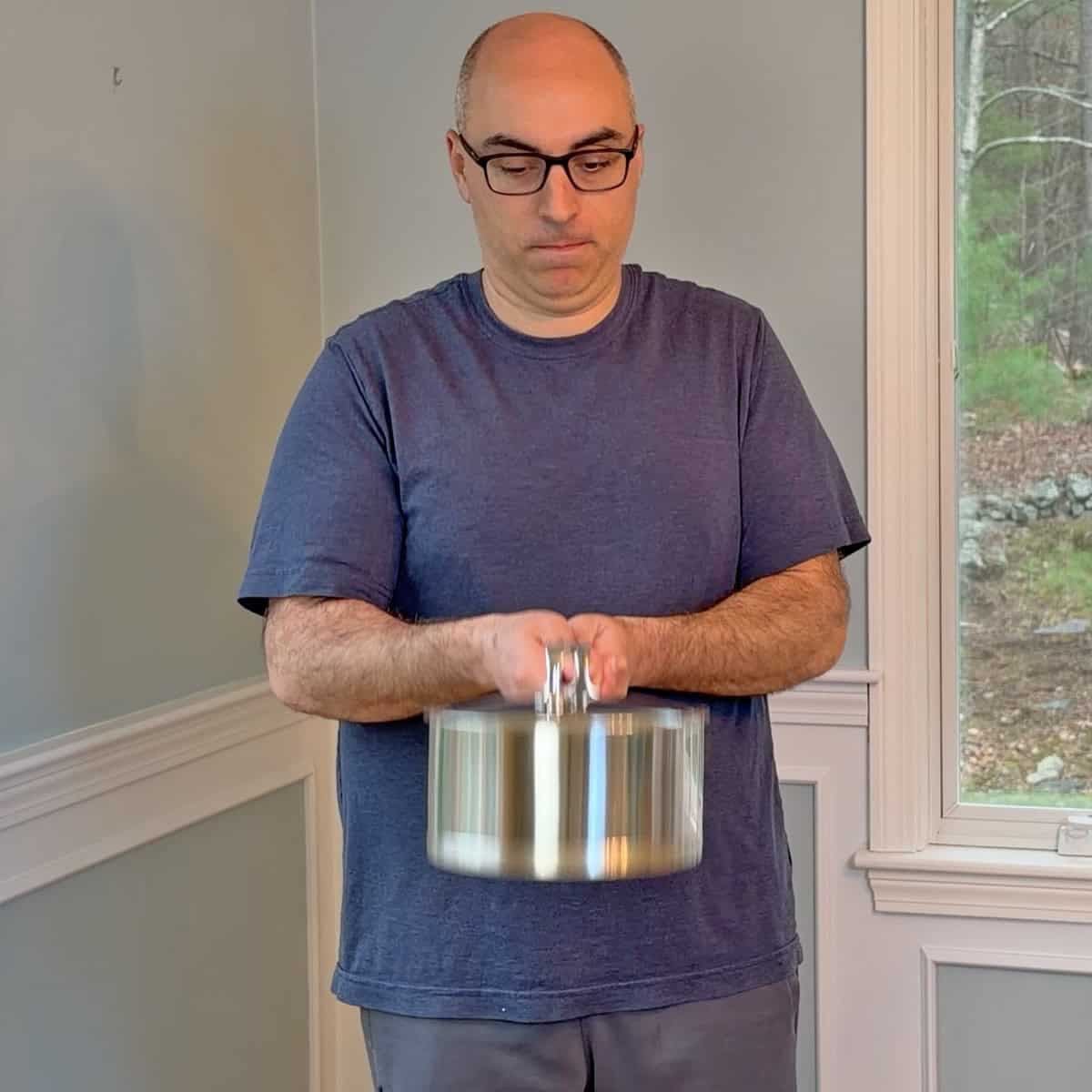 Shaking saucepans full of water to test handle weld strength