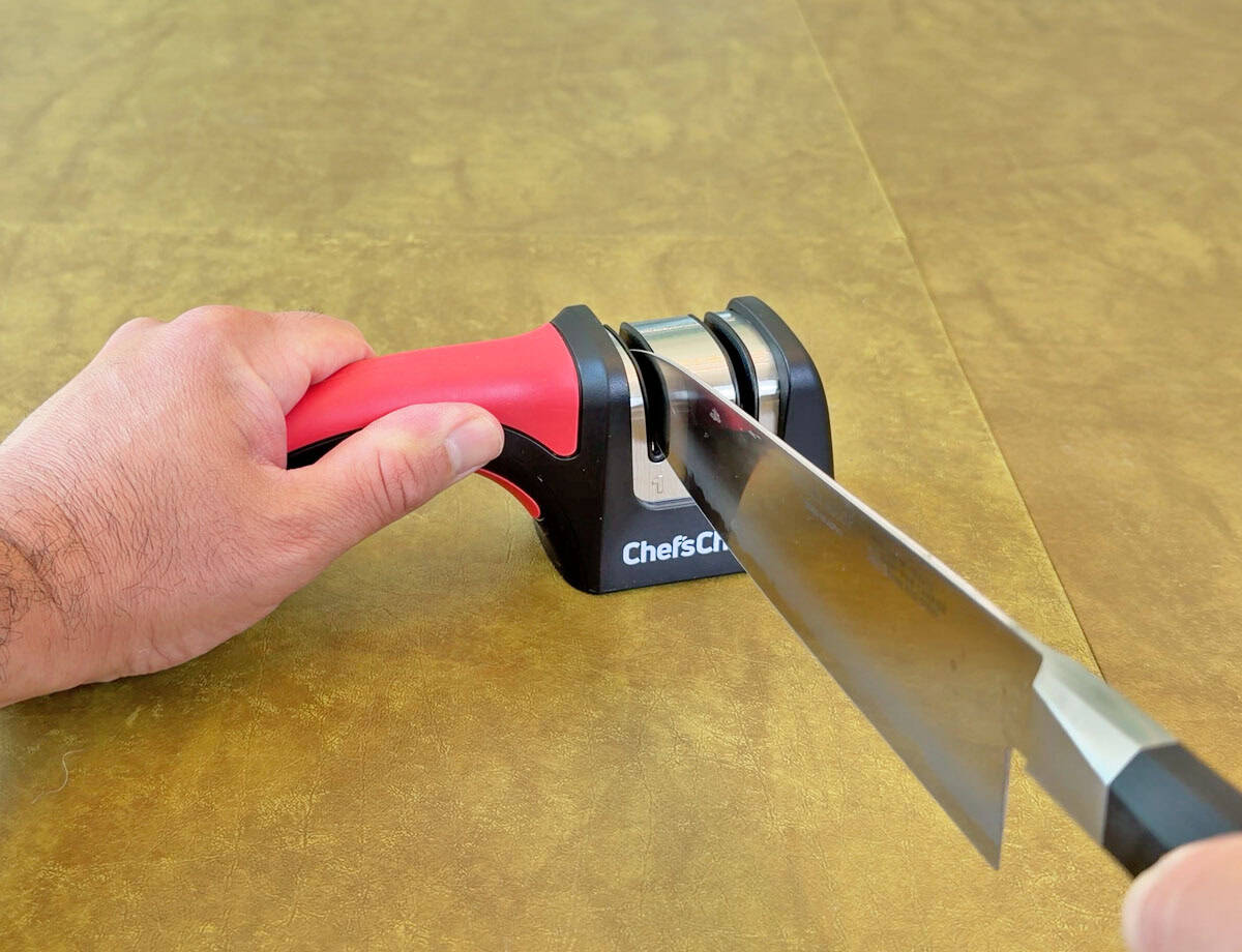 Sharpening a knife with a manual pull through sharpener