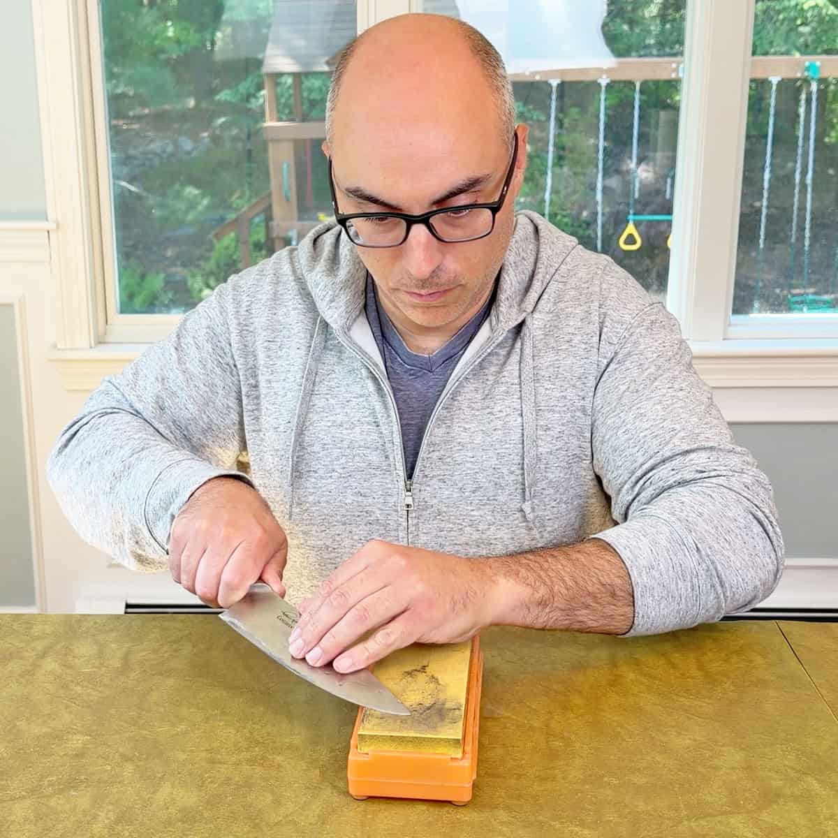 Sharpening a knife with a whetstone from front