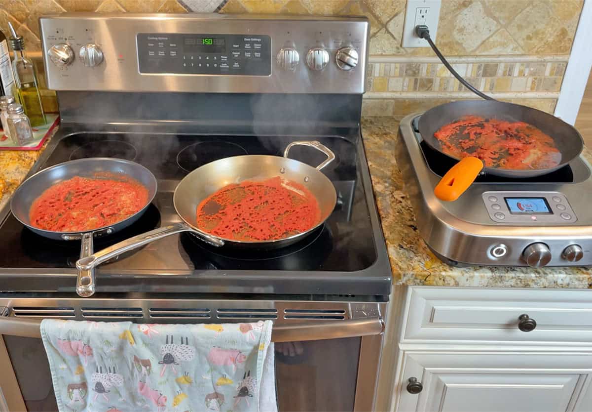 Simmering crushed tomatoes in Misen Carbon Nonstick pan de Buyer Mineral B Pro pan and Lodge carbon steel pan