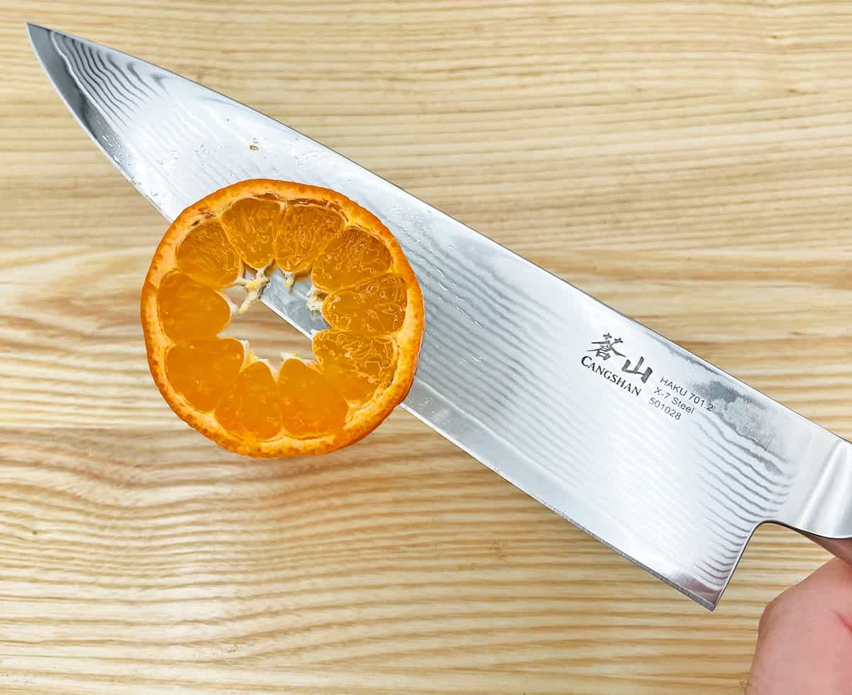 https://prudentreviews.com/wp-content/uploads/Slicing-a-clementine-with-a-Cangshan-Haku-Series-knife.jpg