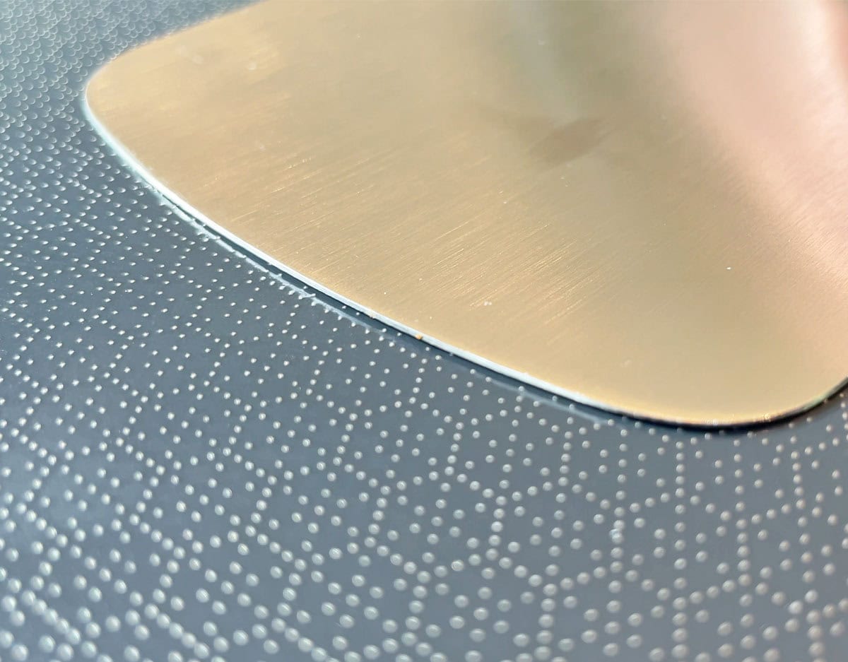 Spatula sliding across raised steel on HexClad hybrid surface